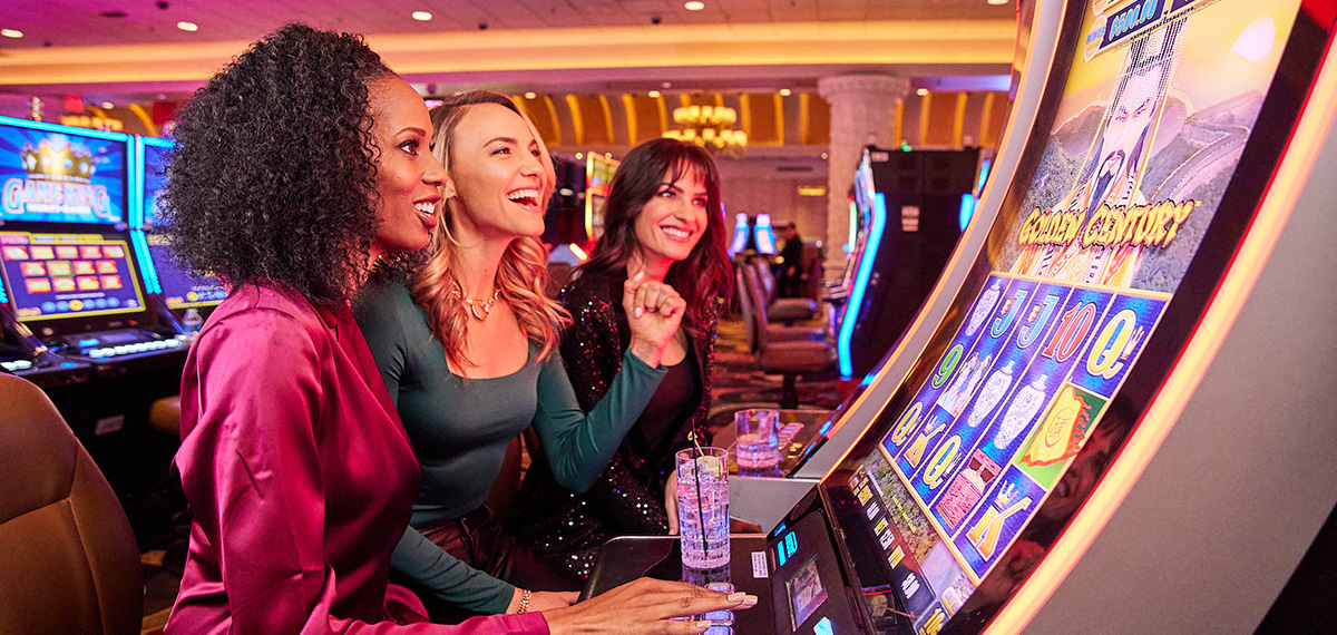 three women smiling in the casino playing slots